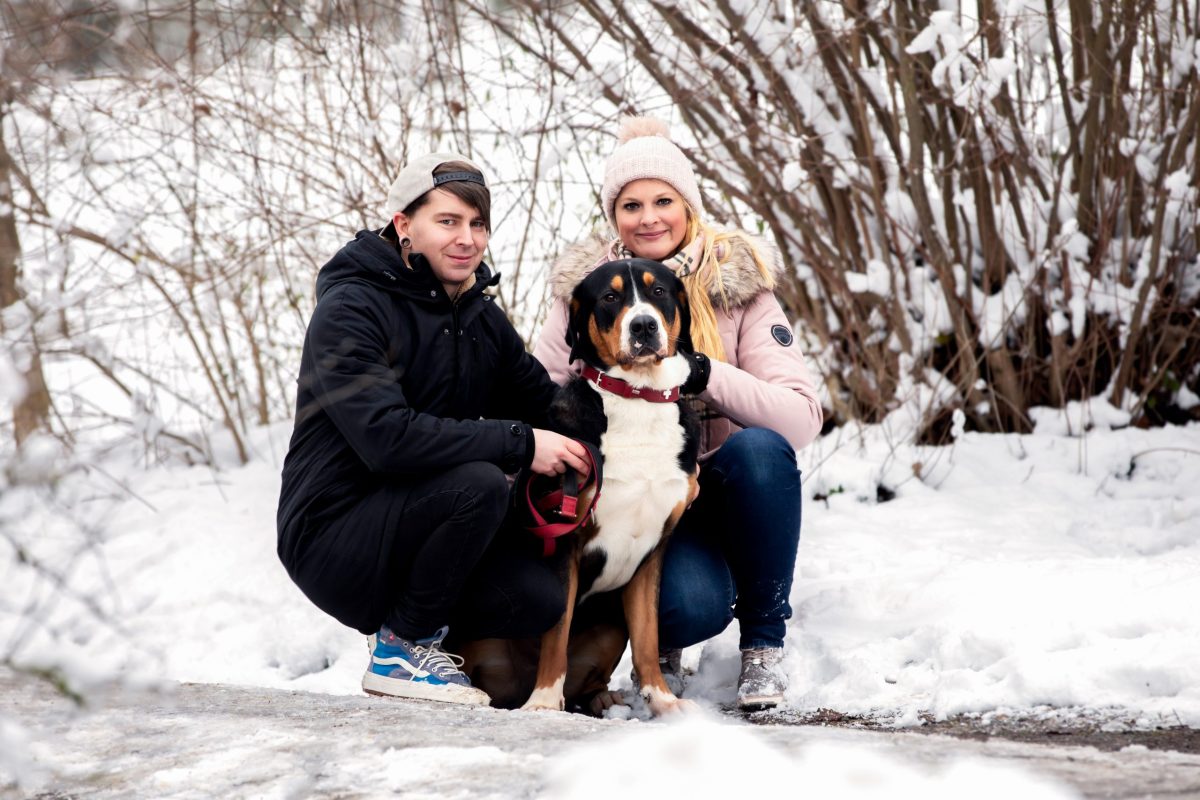 Paar mit Hund bei einem winterlichen Fotoshooting